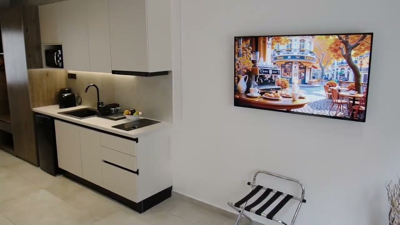 The suite's kitchen with the television on the wall opposite