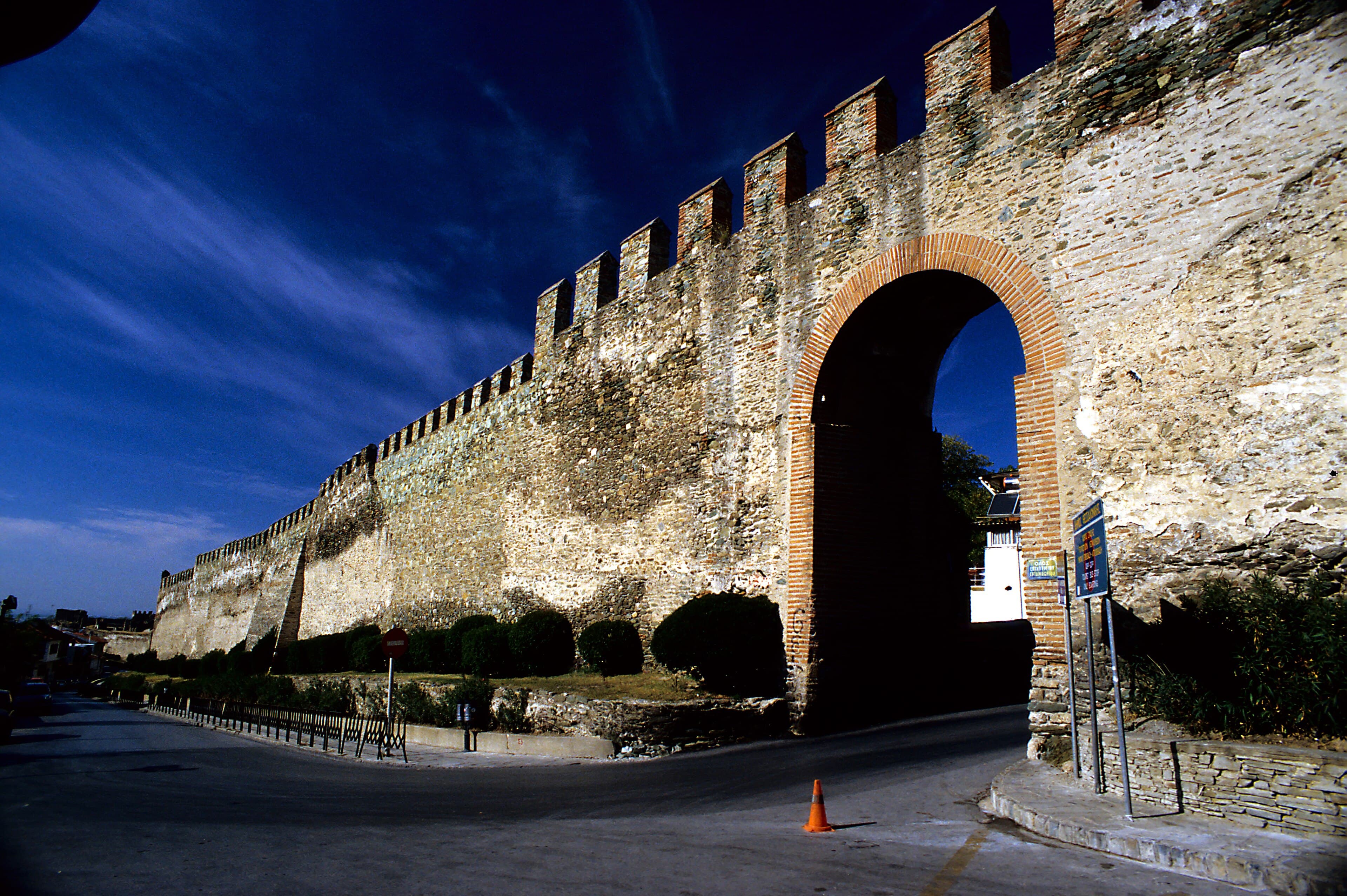 An arched gate in the Byzantine wall, the battlements running downhill beside it